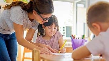 老师 working with two children.